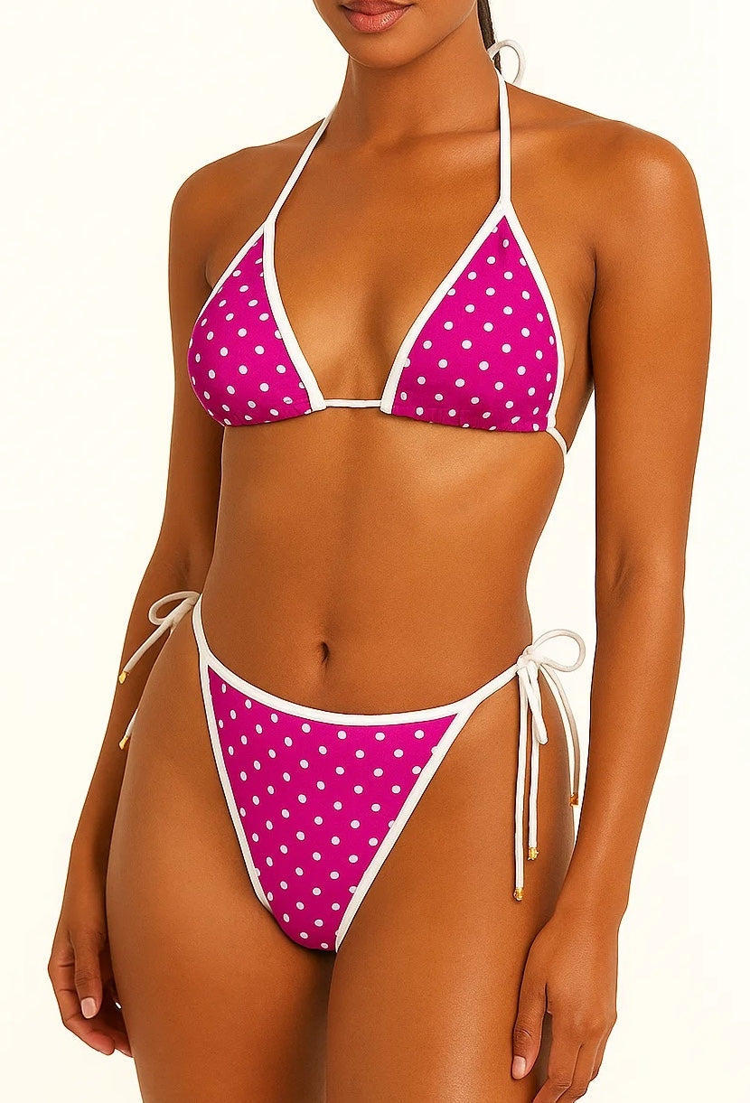 Woman wearing a pink polka dot bikini with white straps on a white background