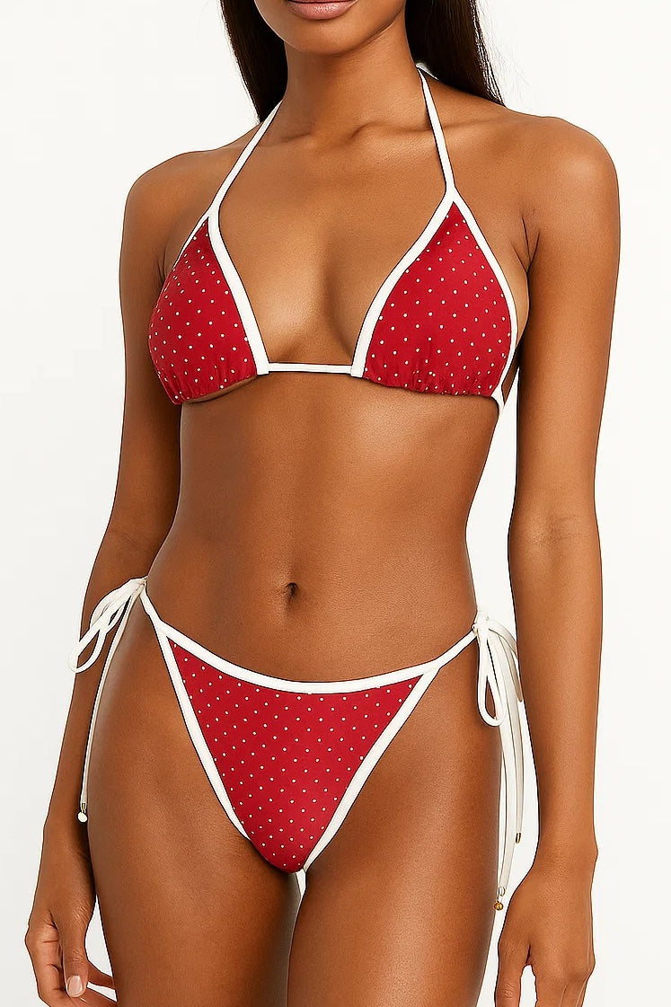 Red polka dot bikini with white straps on a model against a white background